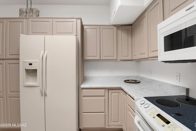 kitchen with a chandelier, light stone counters, and white appliances