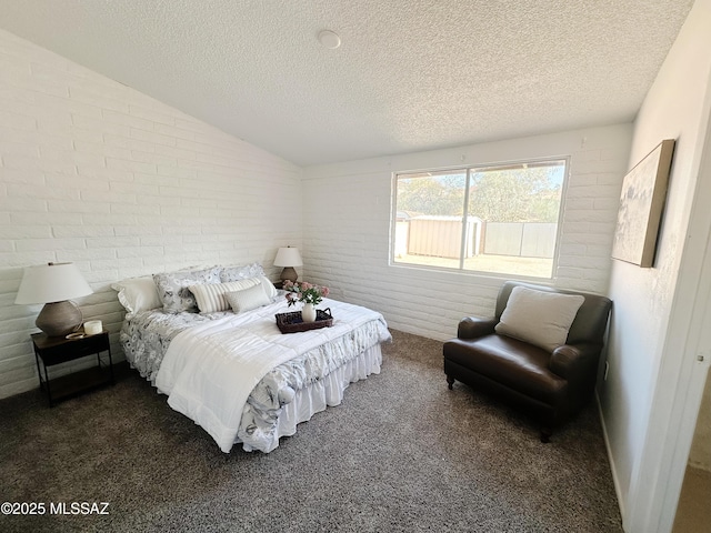 carpeted bedroom with brick wall, a textured ceiling, and vaulted ceiling