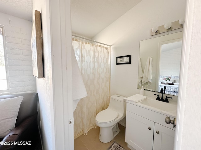 bathroom featuring toilet, vanity, tile patterned flooring, and a textured ceiling