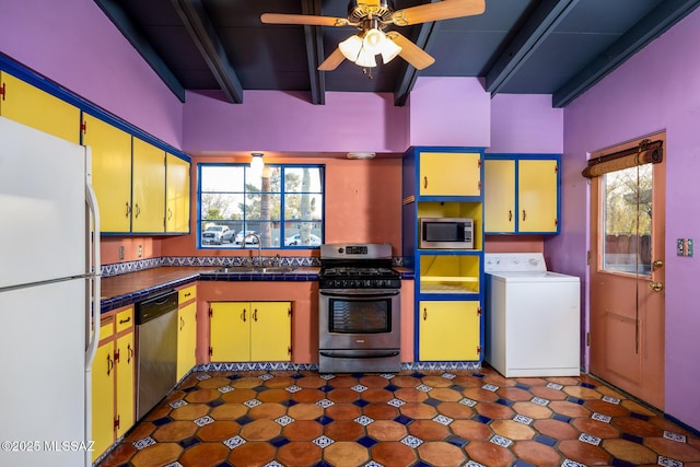 kitchen with sink, appliances with stainless steel finishes, plenty of natural light, beamed ceiling, and washer / clothes dryer