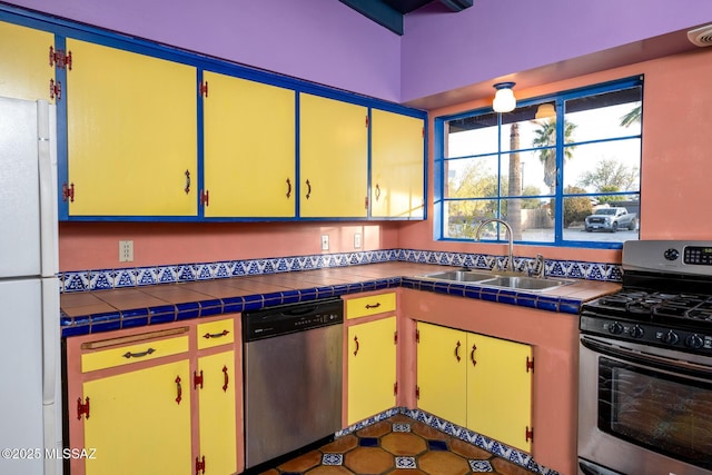 kitchen featuring appliances with stainless steel finishes, sink, and tile countertops