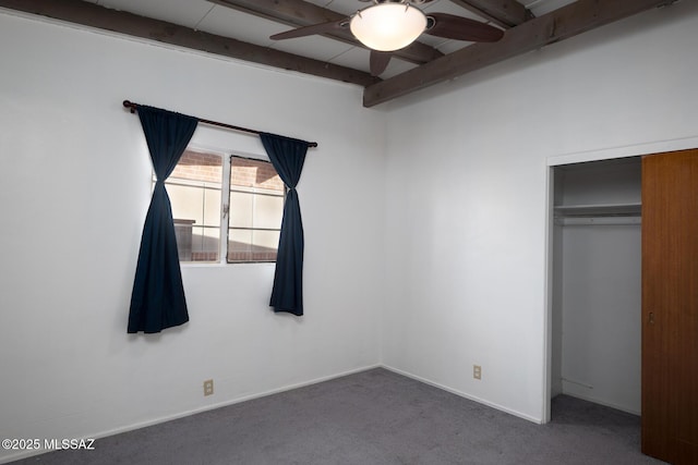 unfurnished bedroom with beamed ceiling, ceiling fan, carpet, and a closet