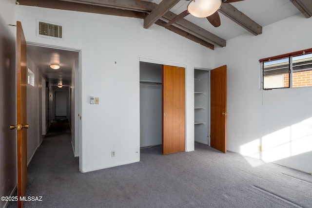 unfurnished bedroom with dark carpet, lofted ceiling with beams, a closet, and ceiling fan