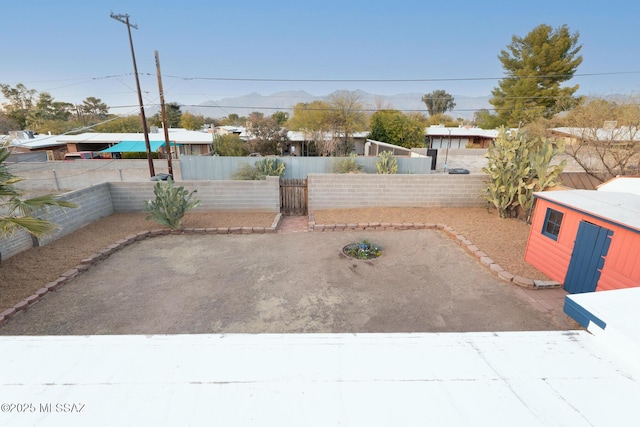 view of yard featuring a patio, a mountain view, and a shed