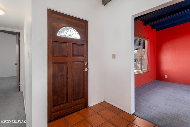 foyer featuring beamed ceiling, tile patterned floors, and plenty of natural light