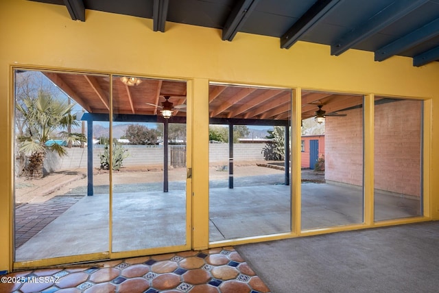 doorway to outside with beamed ceiling