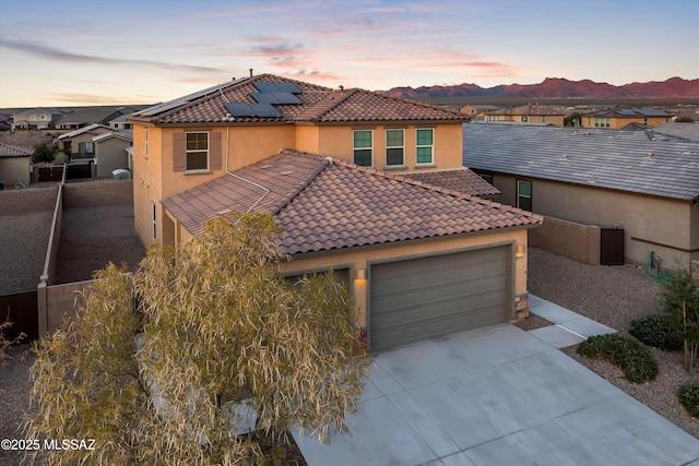 view of front of home featuring a mountain view, a garage, and solar panels