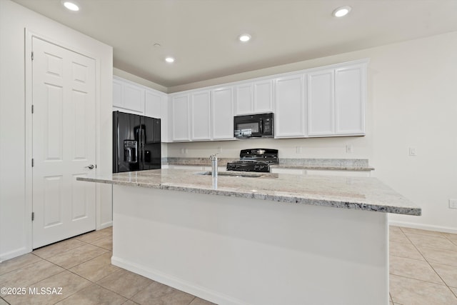 kitchen with light tile patterned flooring, white cabinetry, sink, black appliances, and a center island with sink