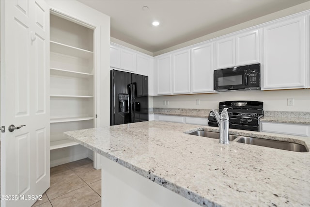 kitchen featuring white cabinetry, light stone countertops, and black appliances