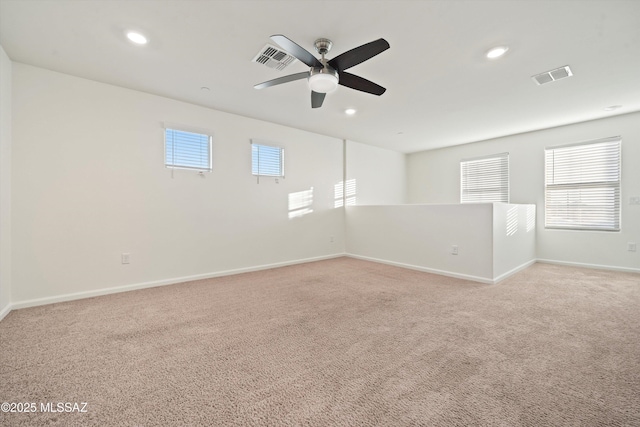 spare room with light colored carpet and ceiling fan