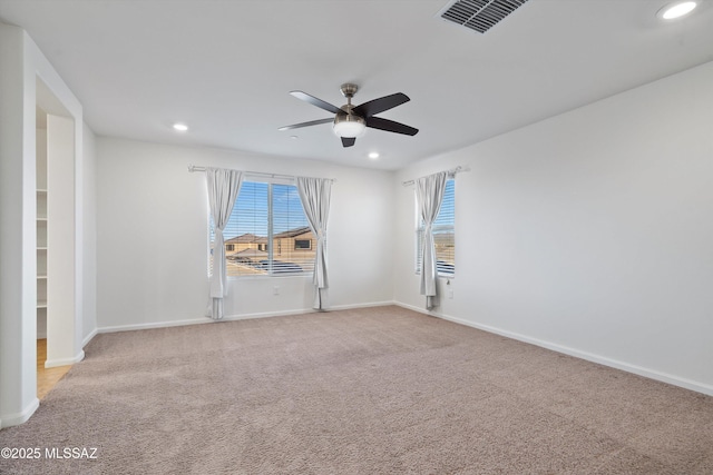 carpeted spare room featuring ceiling fan