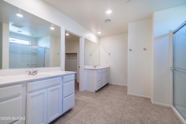 bathroom featuring walk in shower, vanity, and tile patterned flooring