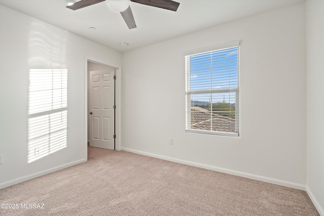 unfurnished room with light colored carpet and ceiling fan