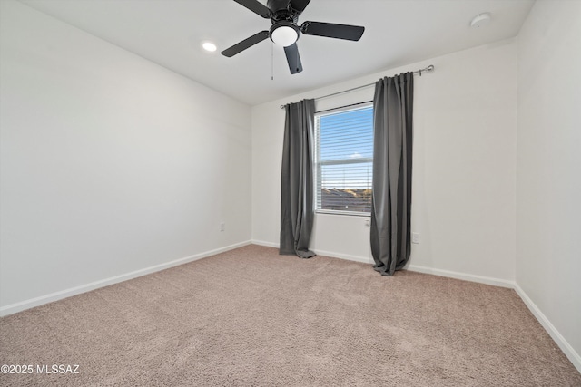 spare room with ceiling fan and light carpet