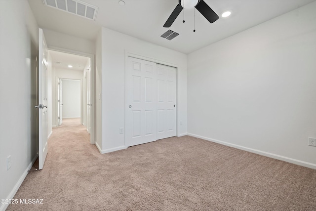 unfurnished bedroom with ceiling fan, light carpet, and a closet