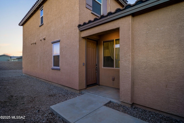 property exterior at dusk featuring a patio area