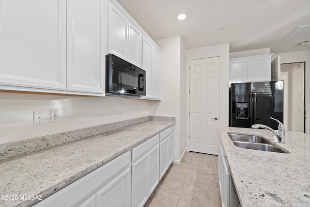 kitchen with light stone counters, sink, black appliances, and white cabinets