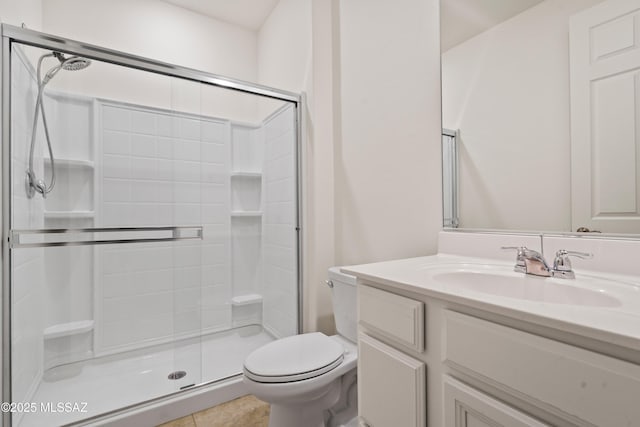 bathroom with vanity, toilet, a shower with door, and tile patterned flooring