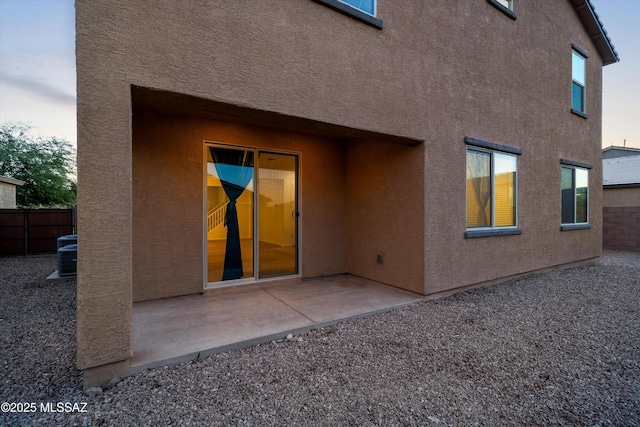 back house at dusk featuring a patio