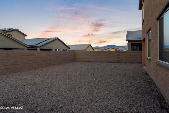 yard at dusk featuring a mountain view and a patio area