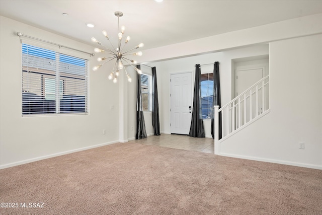 carpeted spare room with a notable chandelier