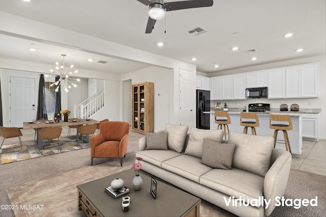 living room featuring ceiling fan with notable chandelier and light tile patterned floors