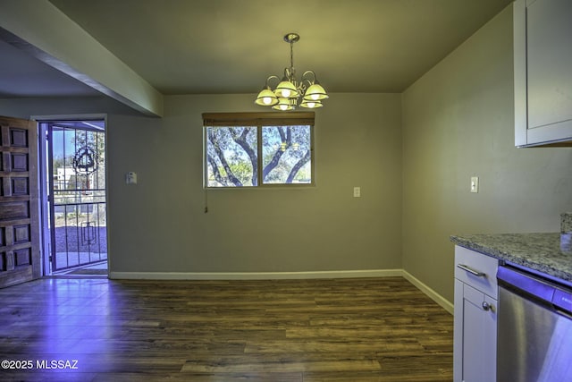 unfurnished dining area featuring an inviting chandelier and dark hardwood / wood-style flooring