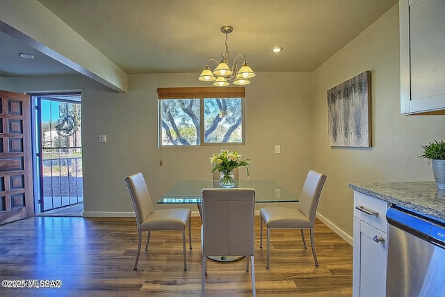 dining area with hardwood / wood-style floors and a notable chandelier