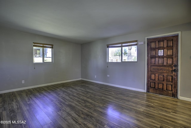 unfurnished room featuring plenty of natural light and dark hardwood / wood-style flooring