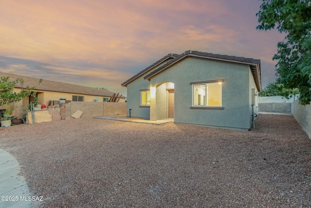 rear view of property with a patio area, a fenced backyard, and stucco siding