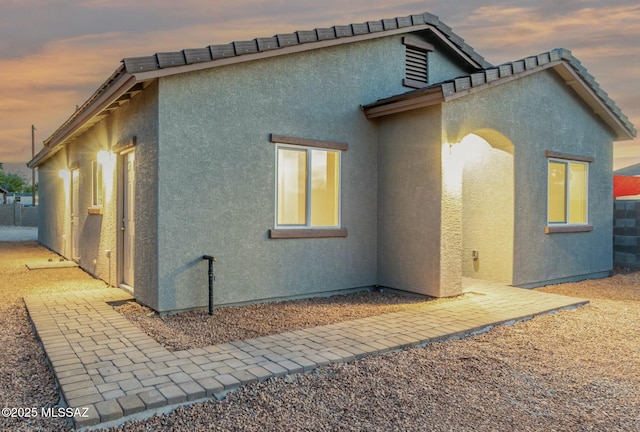 property exterior at dusk with stucco siding