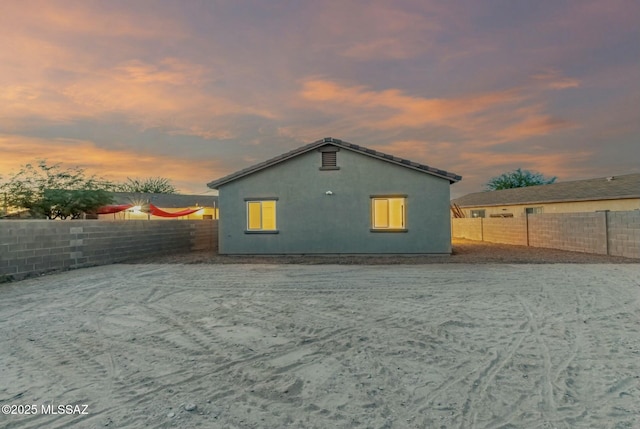 back of house featuring a fenced backyard and stucco siding