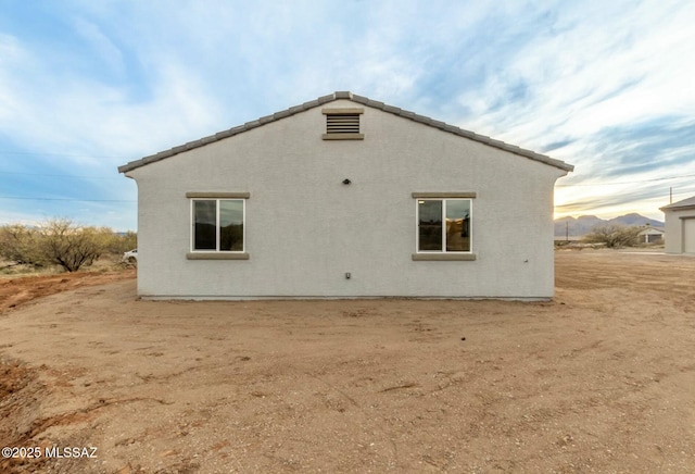 rear view of property featuring stucco siding