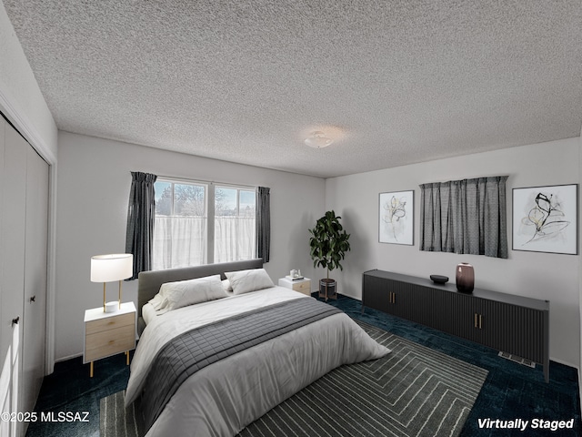 281 E Walker St, Benson, AZ 85602 - bedroom featuring a textured ceiling, a closet, and dark carpet