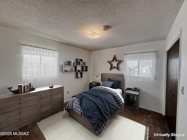 281 E Walker St, Benson, AZ 85602 - bedroom with hardwood / wood-style flooring, a textured ceiling, and a closet