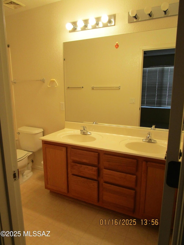 bathroom featuring toilet, tile patterned flooring, and vanity