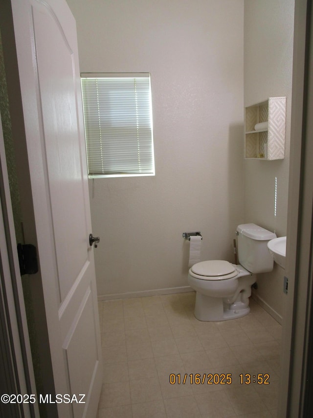 bathroom with toilet and tile patterned flooring