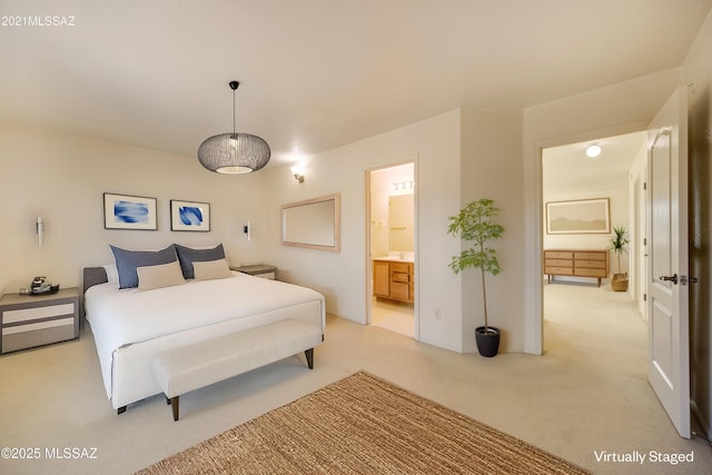 bedroom featuring connected bathroom and light carpet