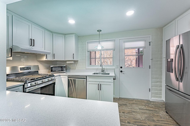 kitchen featuring pendant lighting, sink, white cabinetry, and stainless steel appliances