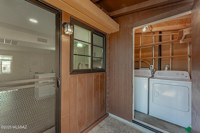 laundry area featuring washing machine and dryer and wooden walls