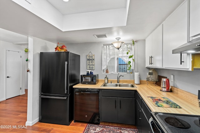 kitchen with light hardwood / wood-style floors, sink, white cabinetry, and black appliances