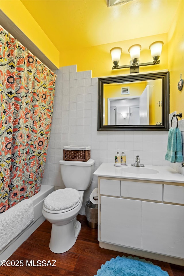 full bathroom featuring toilet, shower / tub combo, wood-type flooring, tile walls, and vanity