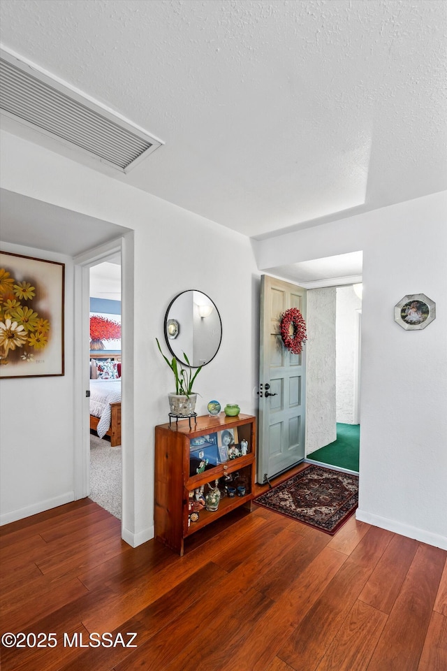 foyer entrance featuring dark hardwood / wood-style floors and a textured ceiling