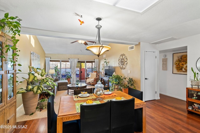 dining space with dark hardwood / wood-style floors and lofted ceiling