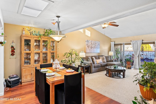 dining area featuring ceiling fan, wood-type flooring, and vaulted ceiling