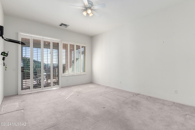 spare room with light colored carpet and ceiling fan