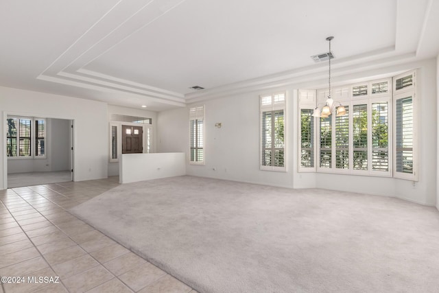 unfurnished living room featuring a raised ceiling, an inviting chandelier, and light tile patterned flooring