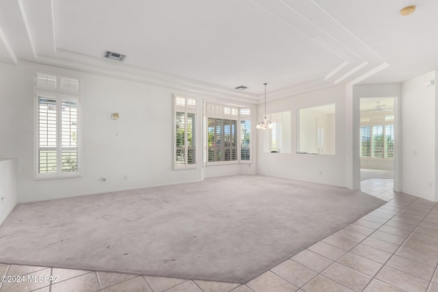 spare room with ceiling fan with notable chandelier, a raised ceiling, and light tile patterned flooring