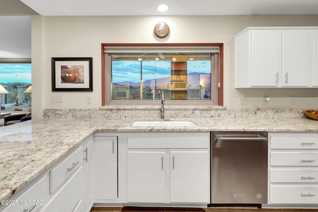 kitchen with light stone countertops, sink, white cabinets, and dishwasher