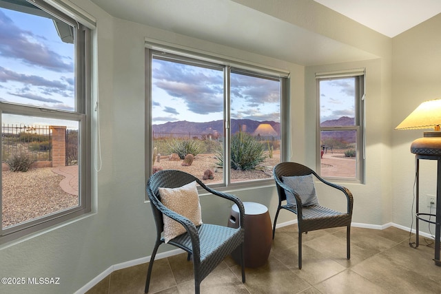 living area featuring light tile patterned floors, plenty of natural light, and a mountain view